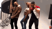 three men are posing in front of a light that says neewer