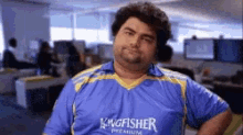 a man wearing a blue shirt that says kingfisher premium on it