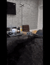 a cat is laying on a couch in a living room next to a table and a television .