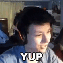 a man wearing headphones with the word yup written on his face