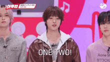 a man in a brown jacket says one two