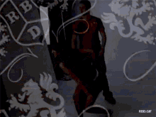 a man in a red shirt is standing in front of a wall with a rbd logo on it