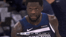 a basketball player wearing a minnesota jersey stands in the stands
