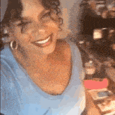 a woman is smiling while taking a selfie in front of a fridge .