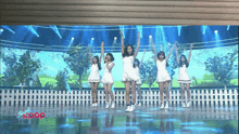 a group of girls are performing on a stage and the word kpop is on the bottom left