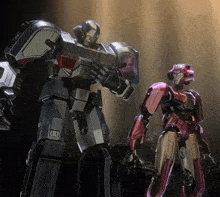 a robot standing next to another robot that has the letter u on it