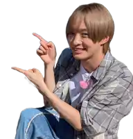 a young man in a plaid shirt is pointing to the right