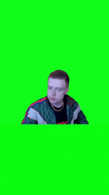 a man in a green jacket is standing in front of a green background .