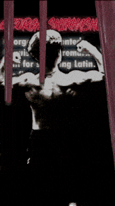 a man flexing his muscles in front of a sign which says " org "