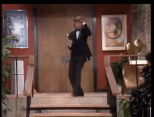 a man in a tuxedo is walking down stairs