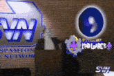 a man stands at a podium in front of a sign that says spamton network