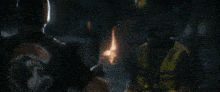 a person holding a torch in the dark with a fire coming out of it