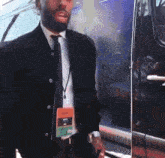 a man in a suit and tie has a lanyard around his neck that has a badge that says ' world ' on it