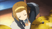 a girl with brown hair and a yellow headband looks down at something