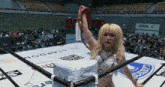 a woman stands in a wrestling ring with a stardom logo on the floor