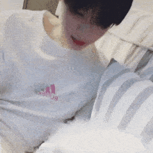 a person wearing a white t-shirt with the word adidas on it