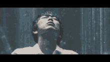 a man in a white shirt and tie is looking up in the rain