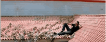 a man laying on a red tiled roof