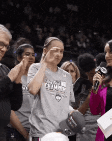 a woman wearing a big east champions shirt