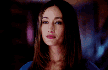 a woman with her eyes closed and a blue shirt on