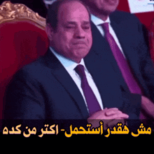 a man in a suit and tie is sitting next to another man in a suit and tie