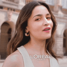 a woman in a white dress is advertising l' oreal paris cosmetics