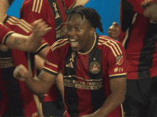 a soccer player wearing a red and black jersey that says american family on it