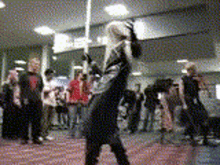 a person in a costume is holding a sword in front of a crowd .