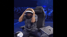 a man is sitting in a chair with his mouth open and headphones on