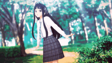 a girl in a plaid skirt and white shirt is standing in a park