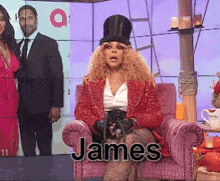 a woman in a red jacket and top hat is sitting in a chair with the name james on it