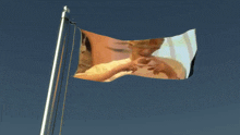 a flag with a picture of a man making a heart with his hands