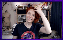 a woman with red hair is wearing a t-shirt with a purple snake on it