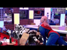 a woman in a superhero costume is kneeling down next to a man