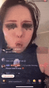 a woman with makeup on her face is making a funny face on a cell phone screen .