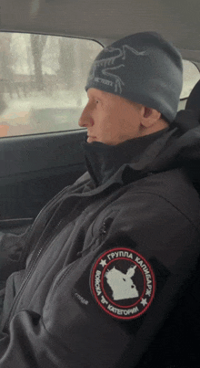 a man wearing a black jacket has a patch on his arm that says группа