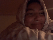 a person wrapped in a white blanket with a hood