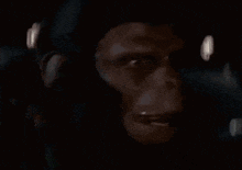 a close up of a monkey 's face in the dark with a blurred background .