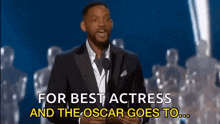 will smith is giving a speech at the oscars while holding a microphone .