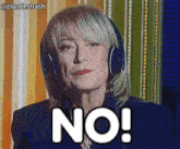 a woman wearing headphones says " no " in front of a striped wall