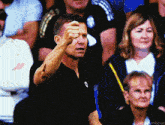 a man in a black shirt is giving the middle finger