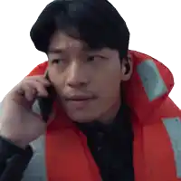 a man wearing a red life jacket talking on a cell phone