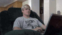a man wearing a shirt that says bronx sits in a chair