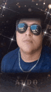 a man wearing sunglasses and a aldo shirt looks at the camera