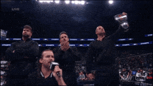 a man is holding a bottle of red bull in front of a live aew show