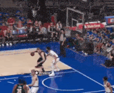 a group of basketball players are playing a game of basketball on a blue court .