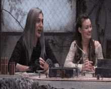 a man and a woman are sitting at a table with a box that says ' a.d. ' on it
