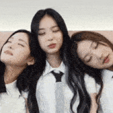three girls are sitting next to each other with their eyes closed .