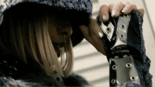 a woman in a hooded jacket is talking on a cellphone