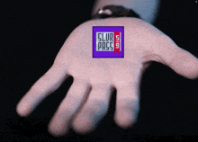 a hand is holding a purple square that says club pass